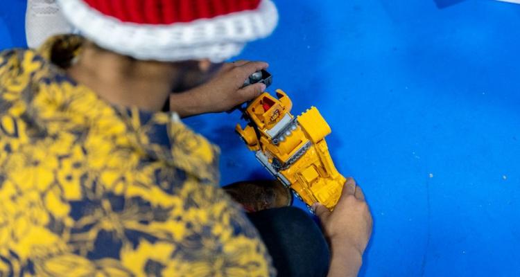 Niño con gorro rojo jugando con un juguete